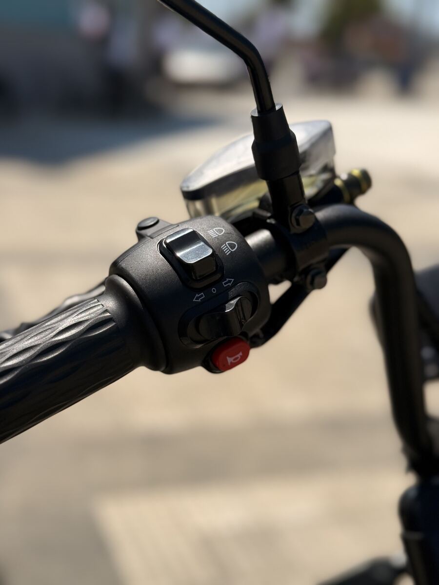 Detalhe dos comandos de luz e seta no guidão da scooter X13